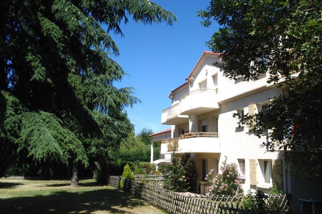 ein weißes Gebäude mit einem Zaun und Bäumen in der Unterkunft Chambre d'hôte Sainte Émilie in Annonay