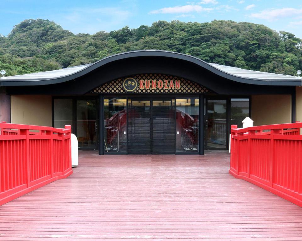 un bâtiment avec un portail rouge et une passerelle en bois dans l'établissement リバティーリゾート久能山, à Komagoe