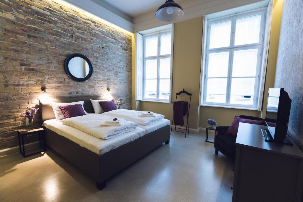 een slaapkamer met een bed en een bakstenen muur bij Heritage Home Apartments in Boedapest