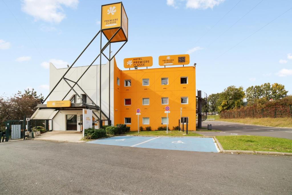 un bâtiment orange avec un panier de basket en face dans l'établissement Premiere Classe Thionville - Yutz, à Yutz