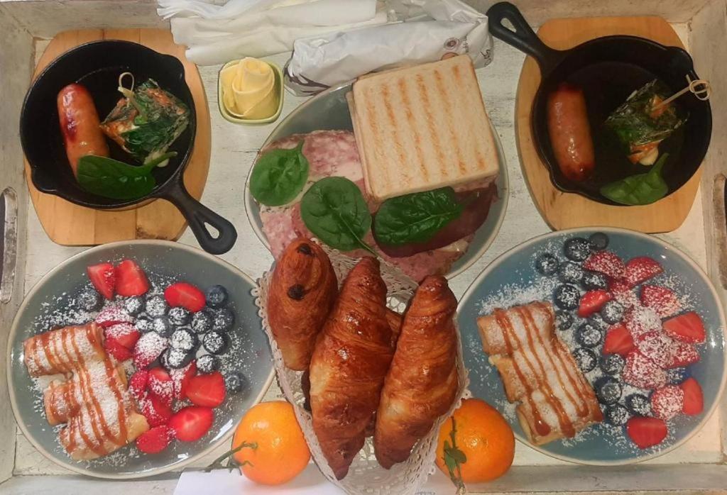 a table topped with plates of food with meat and fruit at Golden Lion in Bouillon