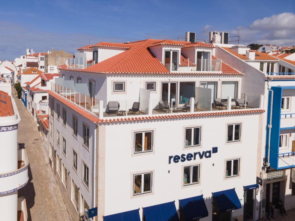 un edificio blanco con techo rojo en Reserva FLH Hotels Ericeira, en Ericeira