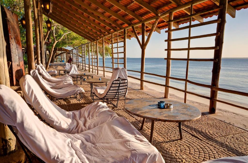 una fila de sillas y mesas en la playa en Mediterraneo Boutique Hotel, en Dar es Salaam