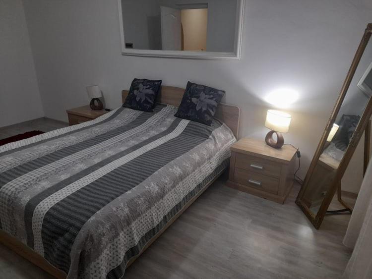 1 dormitorio con 1 cama grande y espejo en New 33, en Bacău