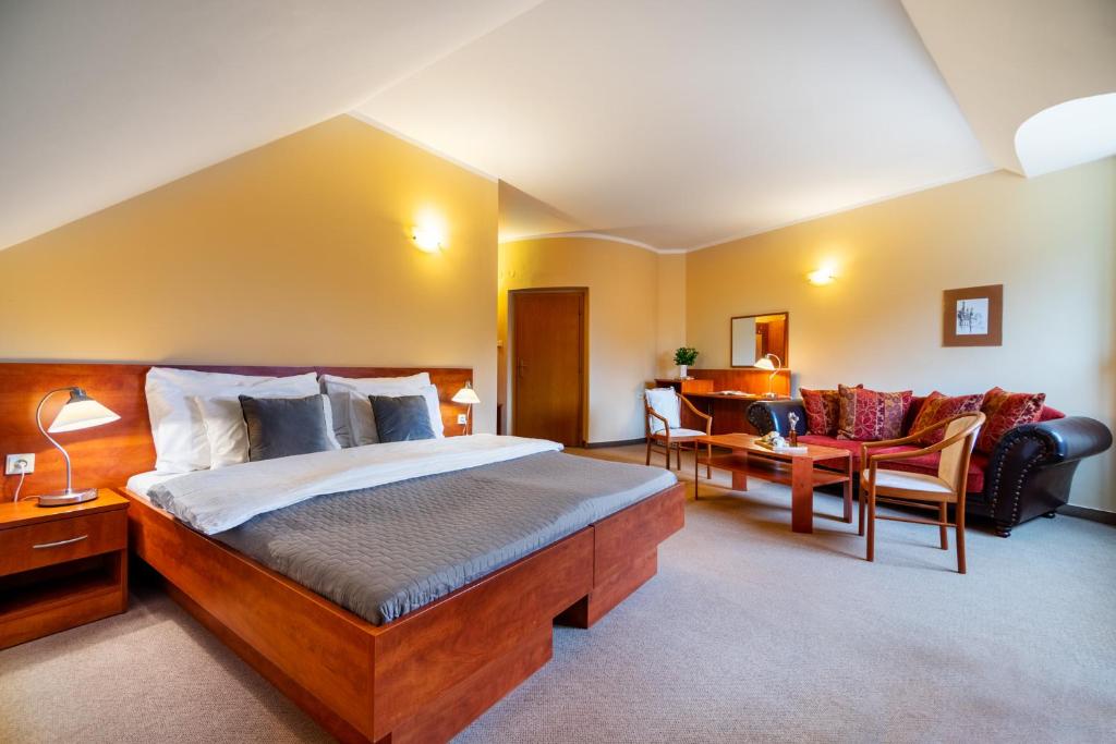 a hotel room with a bed and a couch at Hotel U Vlašského Dvora in Kutná Hora