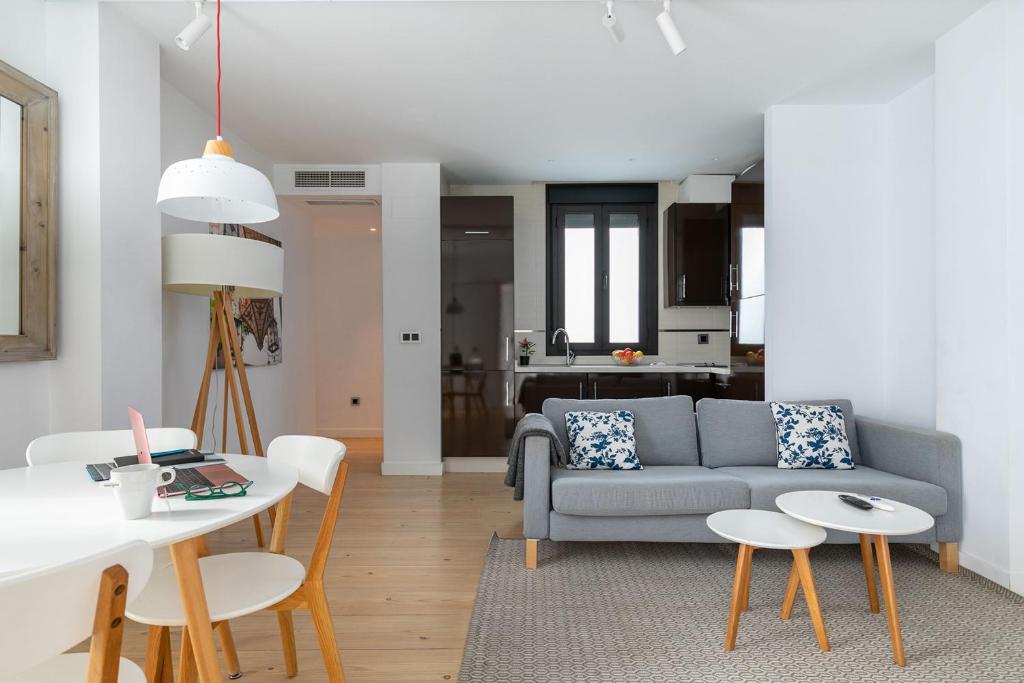 a living room with a couch and a table and chairs at Holiday Rentals Tempa Museo in Seville