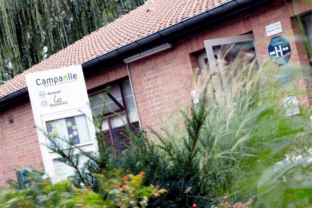 a red brick building with a sign in front of it at Campanile Lille Est - Villeneuve D'ascq in Villeneuve d'Ascq