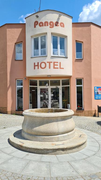 a hotel with a fountain in front of a building at Hotel Pangea in Telč