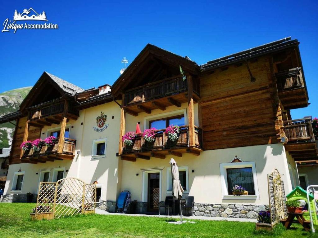 een huis met balkons en bloemen erop bij Al Bait da Valeriano by Livigno Accomodation in Livigno