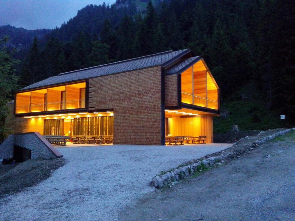 ein Backsteinhaus mit großen Fenstern auf einem Hügel in der Unterkunft Vallesinella Hotel Restaurant Bar in Madonna di Campiglio