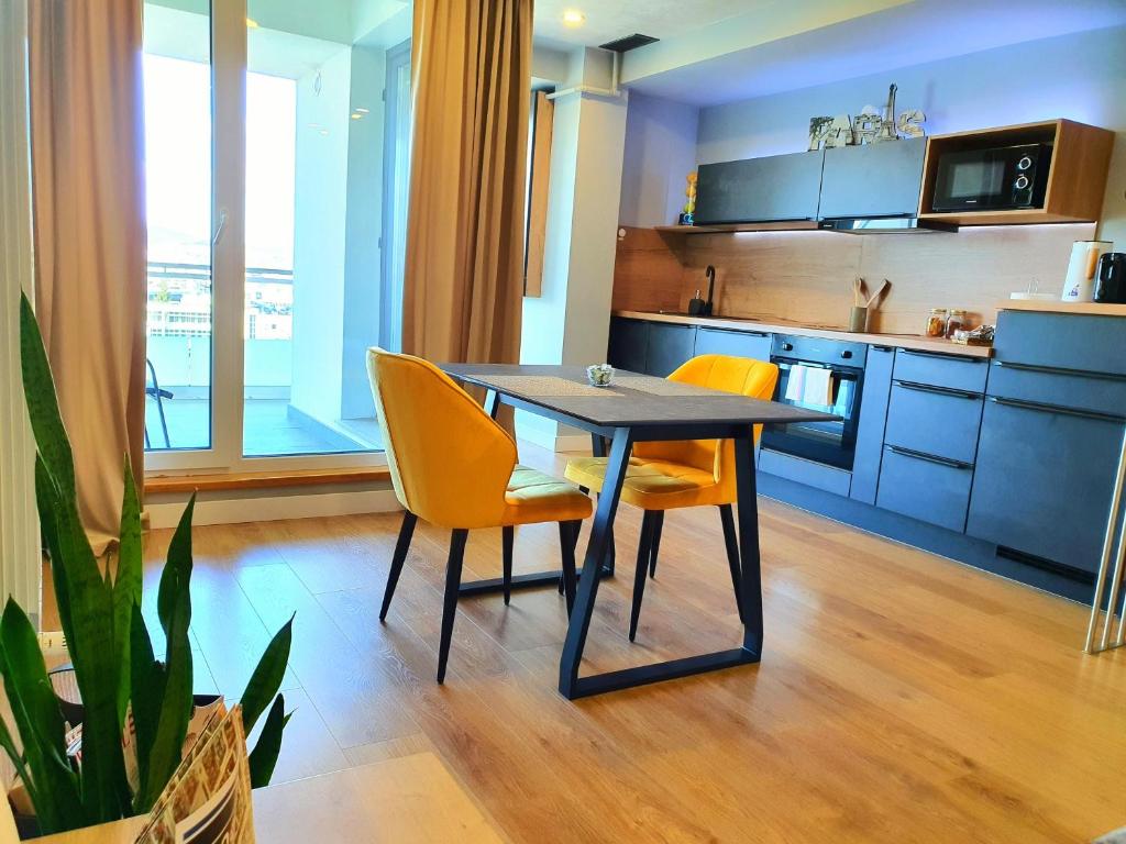 una cucina con tavolo e alcune sedie gialle di Eriss Studio Suite - OZone building apartment a Cluj-Napoca