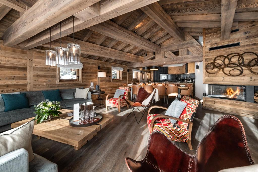 een woonkamer met meubilair en een open haard bij Alaska Lodge by Alpine Resorts in Val dʼIsère