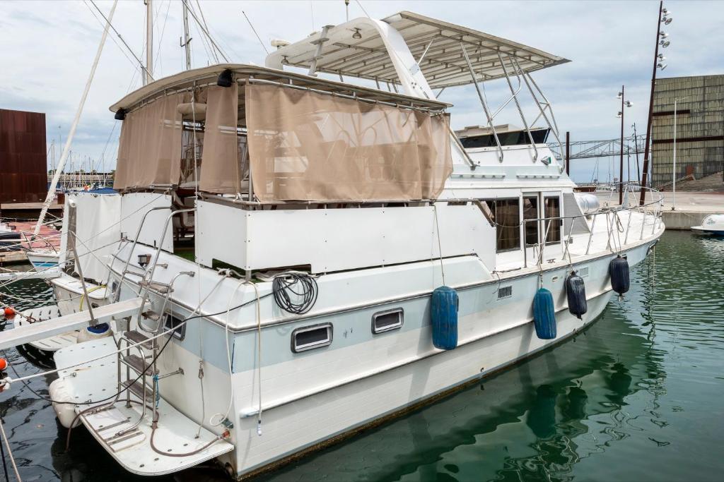 un barco blanco atracado en un muelle en el agua en Boat Accommodations Barcelona, en Barcelona