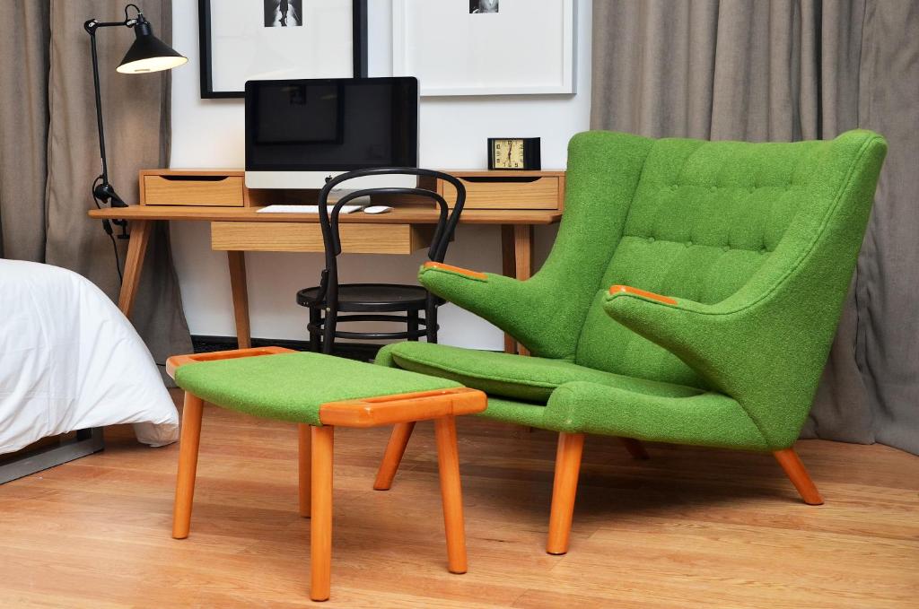 a green chair and a stool in front of a desk at Browns Boutique Hotel in Lisbon