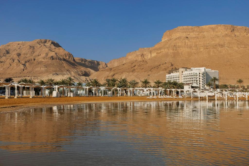 um hotel numa praia com uma montanha ao fundo em Herbert Samuel Hod Dead Sea Hotel em Ein Bokek