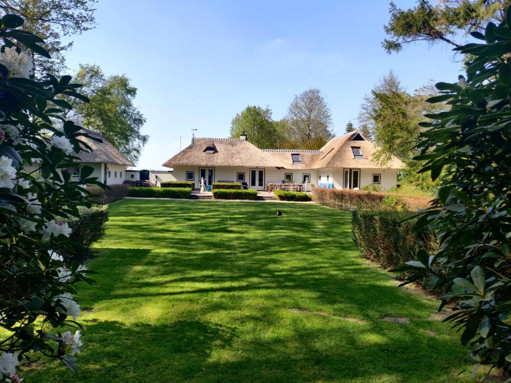 una casa con un gran patio con flores blancas en Hof van Yde, en Yde