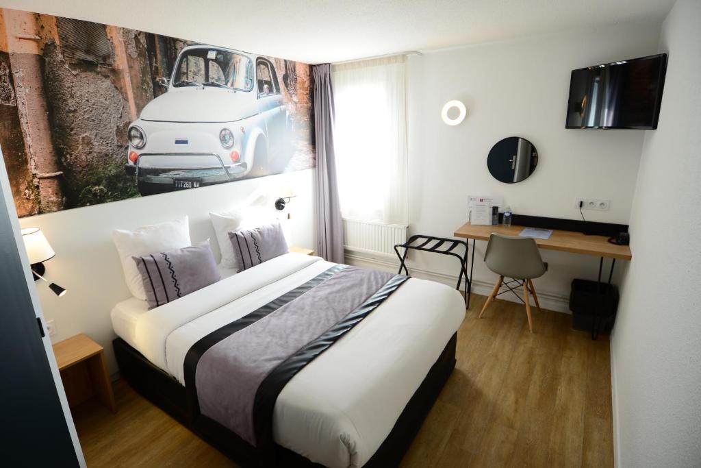 um quarto com uma cama com uma fotografia de um carro na parede em Logis Cris Hôtel, Lyon Est em Corbas