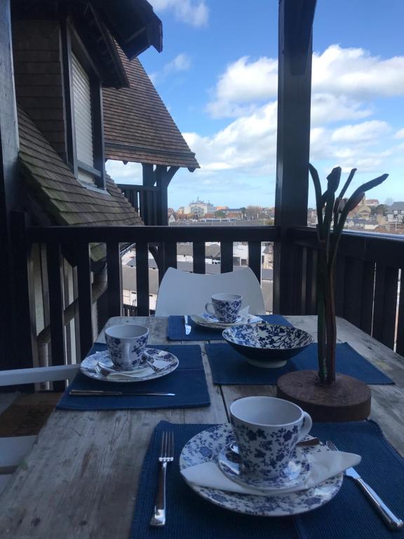 une table avec des plats bleus et blancs sur un balcon dans l'établissement le Pullman, à Deauville