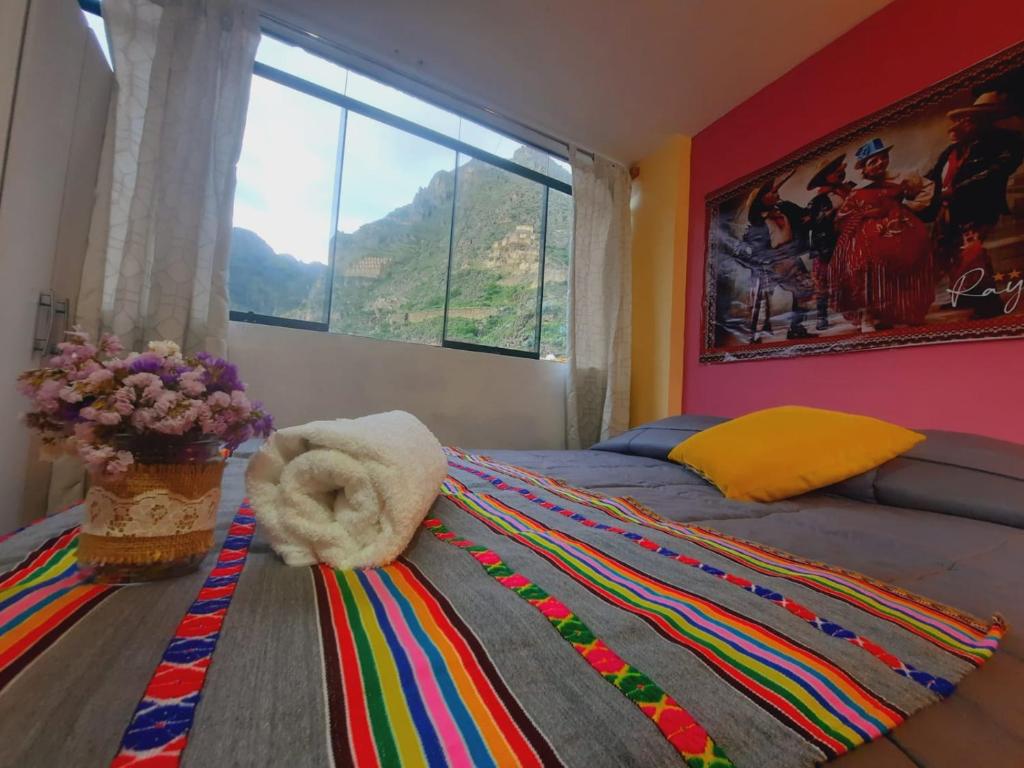 1 dormitorio con 1 cama y ventana grande en Hostal Raymi, en Ollantaytambo