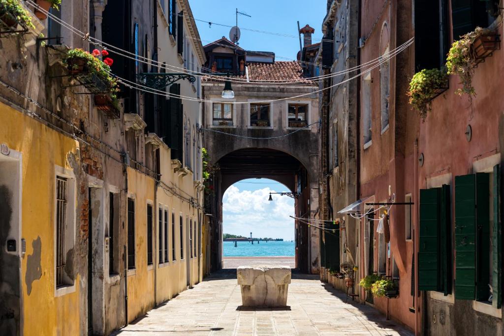 um beco com vista para o oceano através de um arco em Bricola Biennale Apartments em Veneza