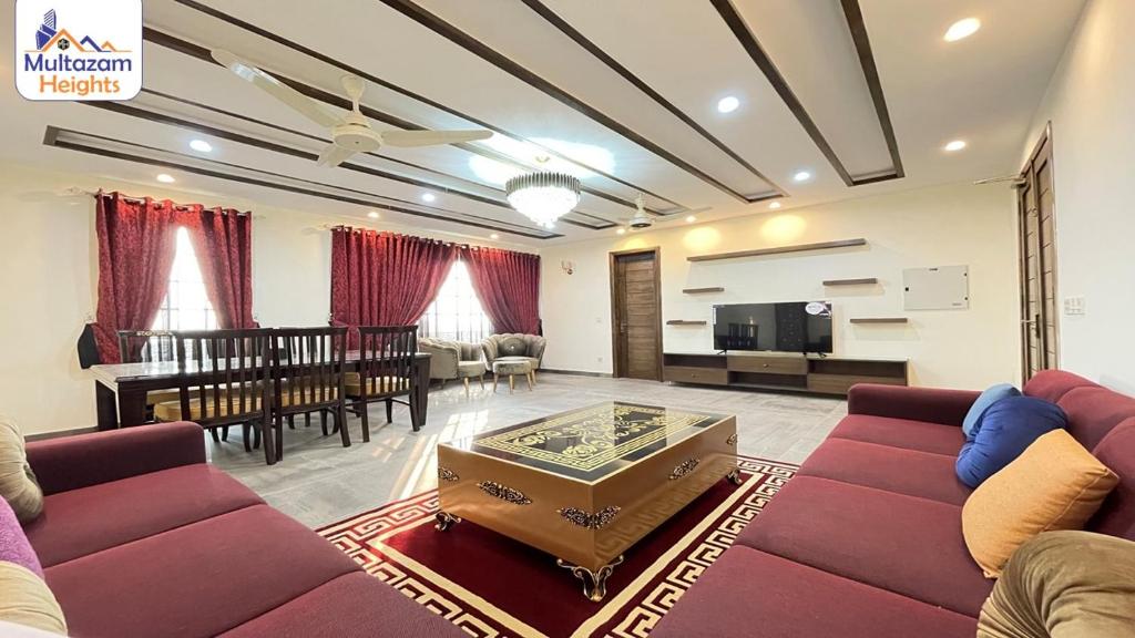 uma sala de estar com um sofá e uma sala de jantar em Multazam Heights, DHA Phase 8 - 3 Bedrooms Luxury Apartments em Lahore