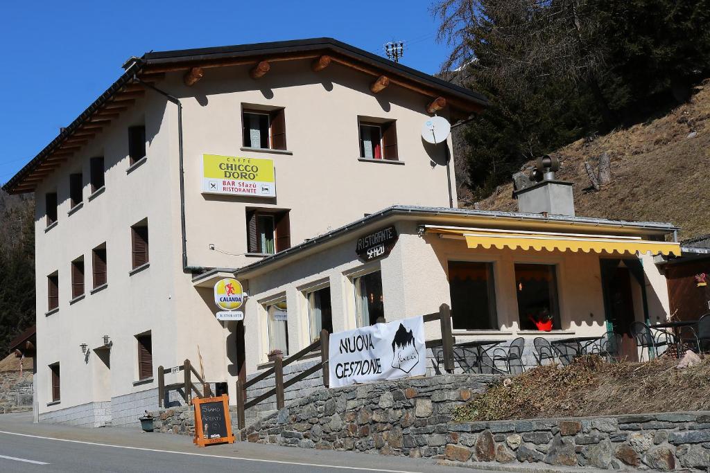 un edificio al lado de una colina con un cartel en Hotel Sfazù, en Poschiavo