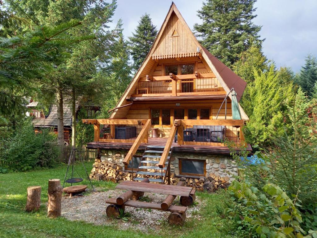 uma cabana com uma mesa de piquenique em frente em Dacza Zakątek em Falsztyn