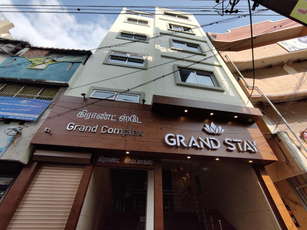 蒂鲁奇奇拉帕利Hotel Grand Stay的一座高大的建筑,上面有大公司的标志