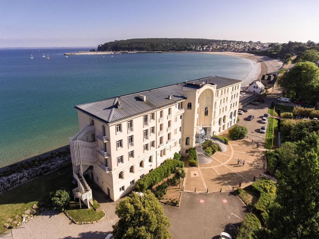 een luchtzicht op een gebouw naast een strand bij Hôtel Morgat Le Grand Hôtel De La Mer in Crozon