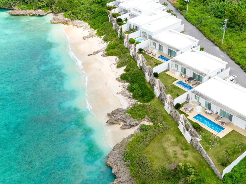 eine Luftansicht auf einen Strand mit weißen Häusern in der Unterkunft Crystal Villa Miyakojima Sunayama Beach in Miyako-jima