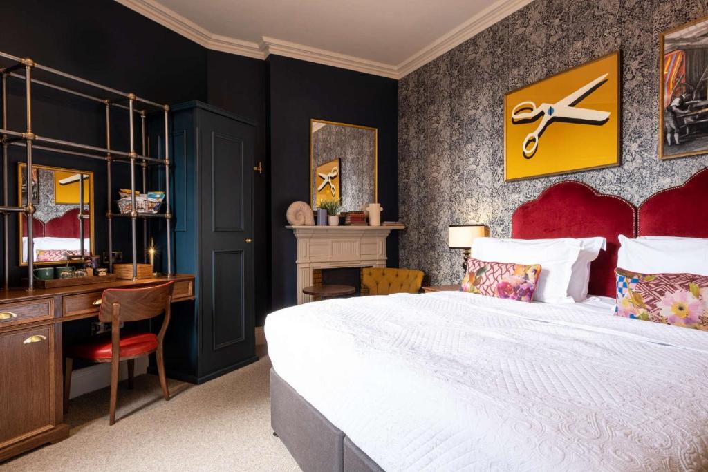 een slaapkamer met een groot bed en een bureau bij Spread Eagle in Londen