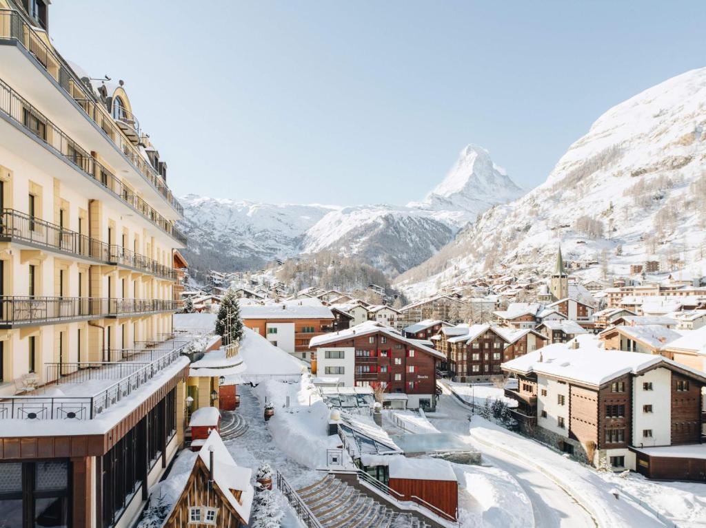 una città ricoperta di neve con montagne sullo sfondo di BEAUSiTE Zermatt a Zermatt