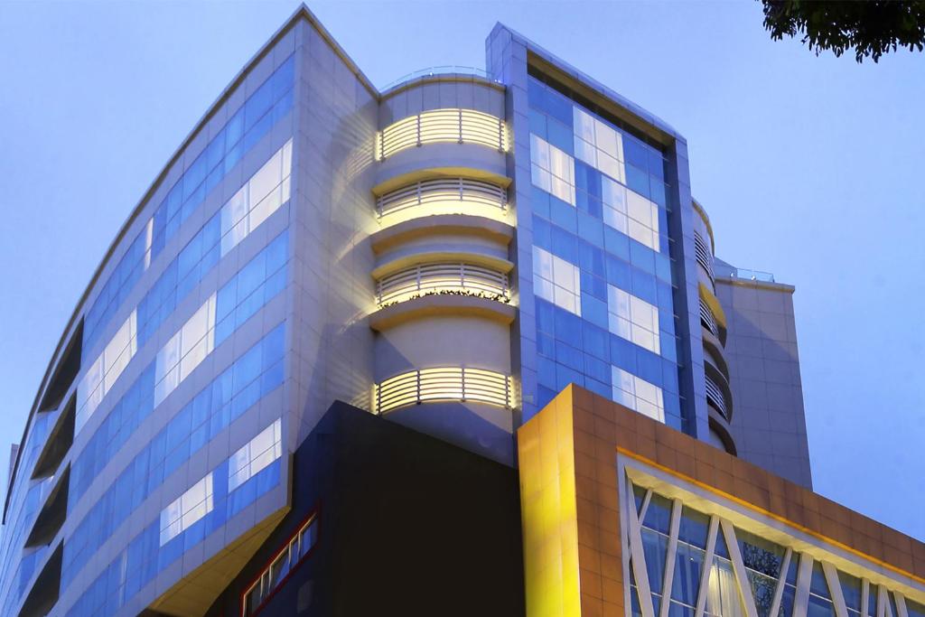 a tall glass building with a blue sky in the background at THE 1O1 Malang OJ in Malang