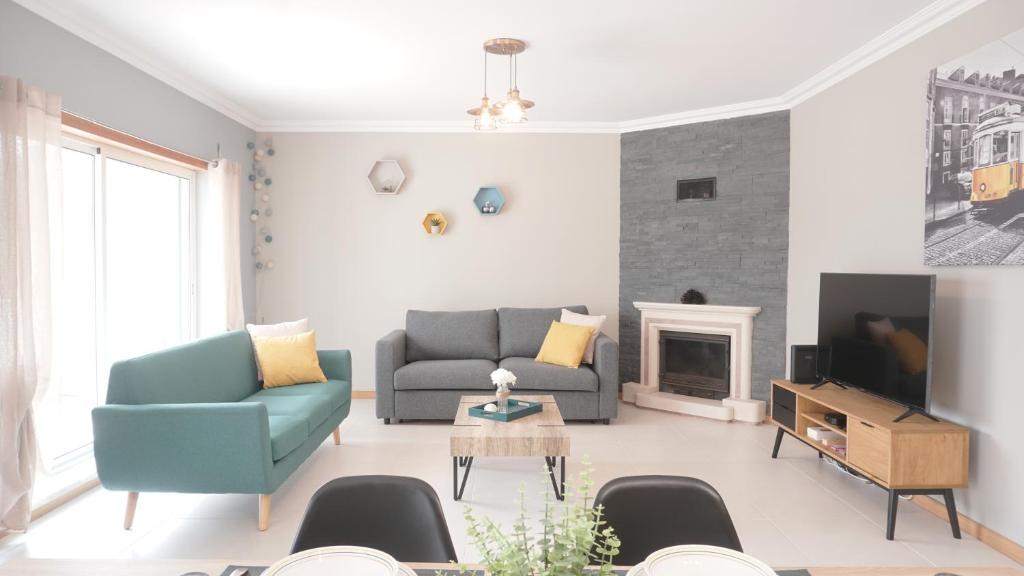 a living room with a couch and a tv at Terraço dos Rabujas in Nazaré