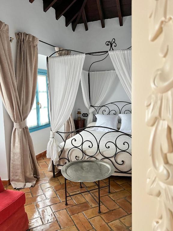 - une chambre avec un lit noir et blanc et des rideaux dans l'établissement Hotel Servilia, à Carmona