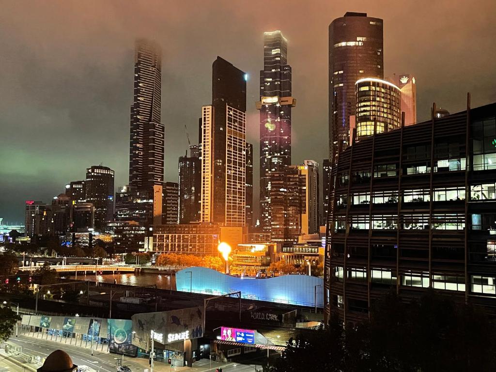 a city skyline at night with tall buildings at ‘Sunrise on Aura’ Apartment with stunning views. in Melbourne