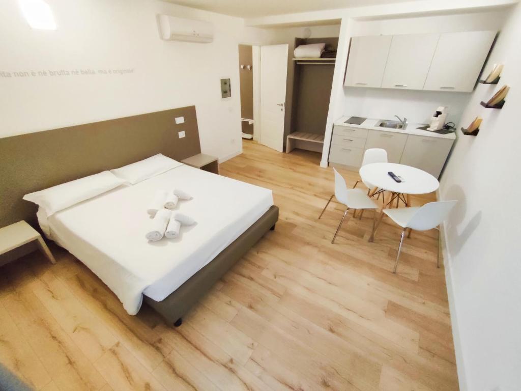 ein Schlafzimmer mit einem Bett und einem Tisch sowie eine Küche in der Unterkunft City Gallery Apartments in Triest