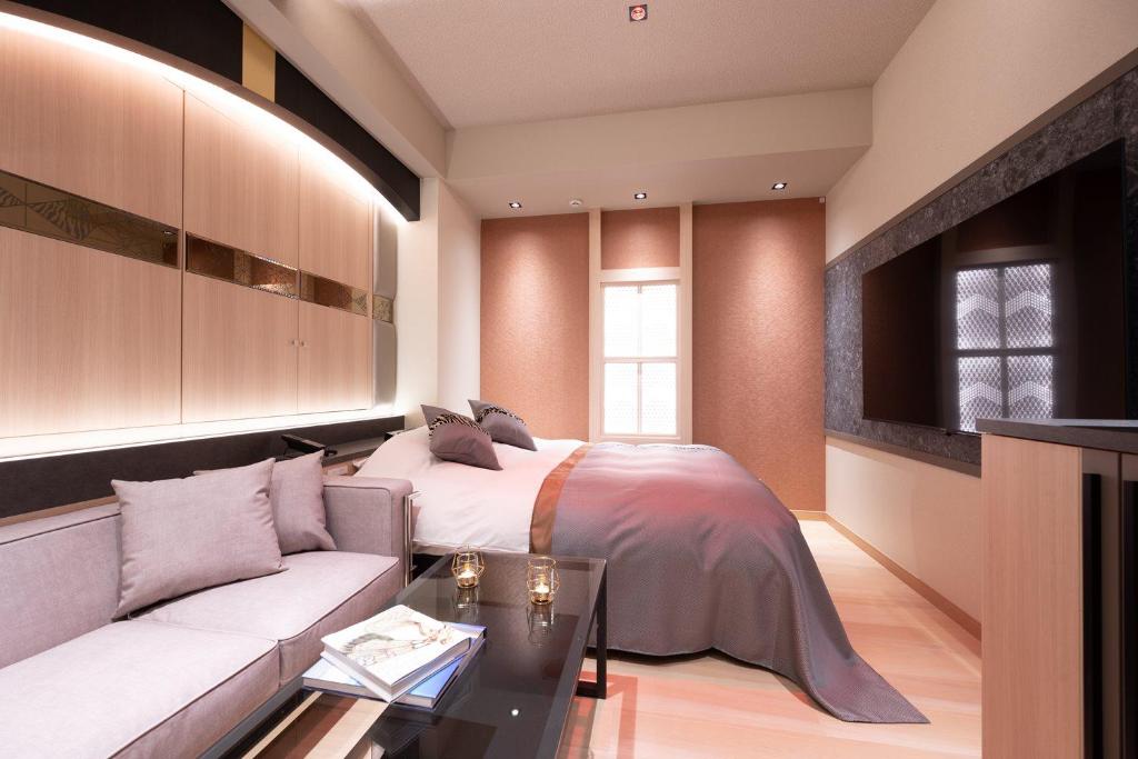 um quarto com uma cama e um sofá em HOTEL K-NEXT em Saitama