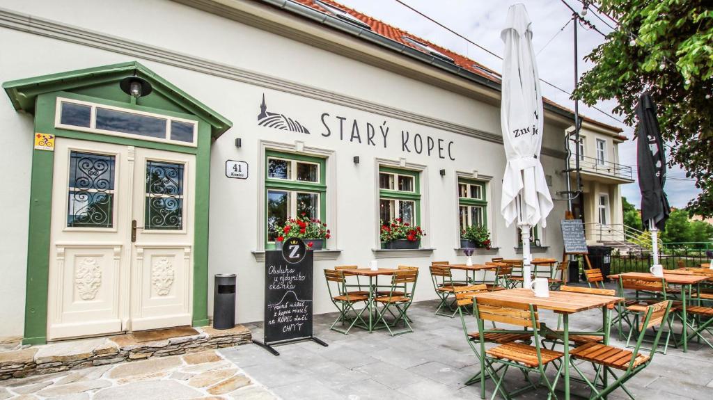 um restaurante com mesas e cadeiras em frente a um edifício em Penzion a bistro Starý kopec em Znojmo