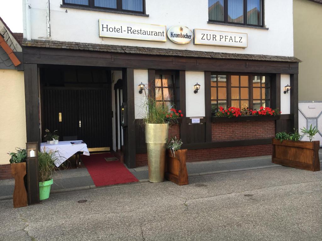 um restaurante de hotel com uma mesa em frente a um edifício em Hotel und Restaurant -Gasthaus Zur Pfalz em Hockenheim