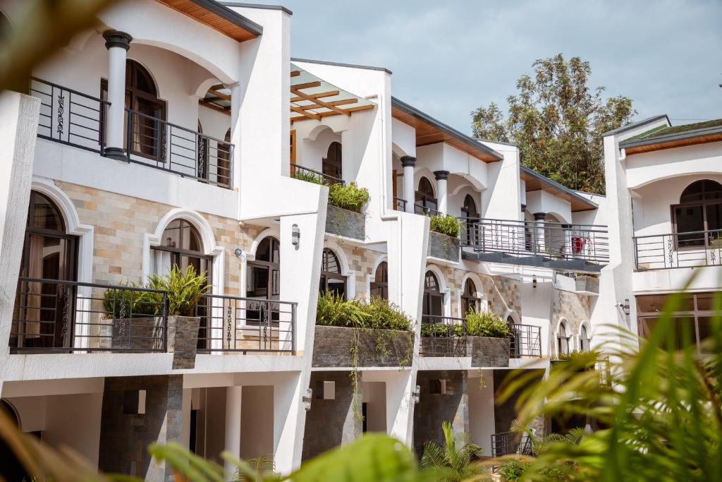 een rij witte gebouwen met planten op balkons bij Ndaru Luxury Suites in Kigali