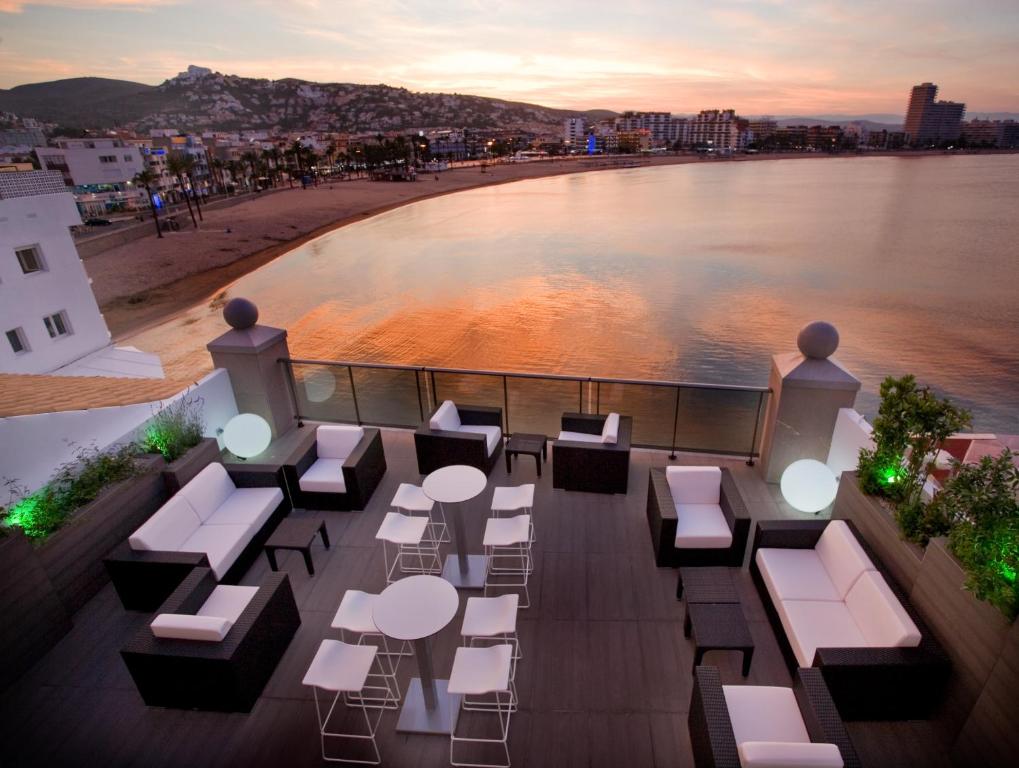 d'un balcon avec des tables et des chaises et une vue sur l'eau. dans l'établissement Hotel Boutique La Mar - Adults Only, à Peñíscola