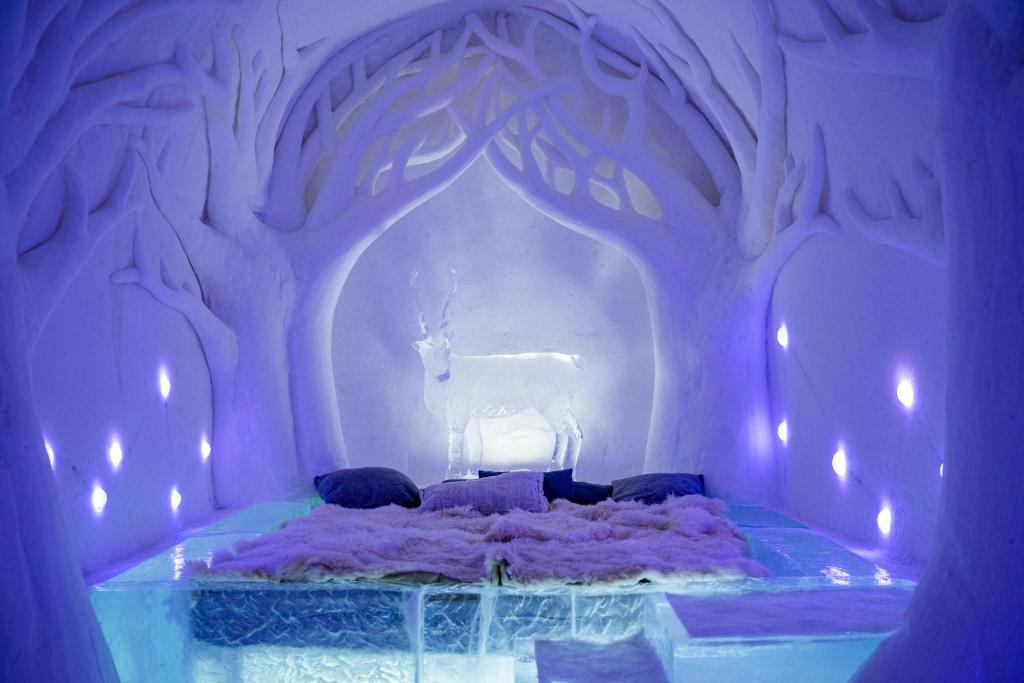 a room with a bed with a deer on it at Sorrisniva Igloo Hotel in Alta