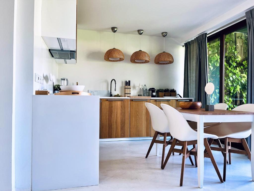 - une cuisine et une salle à manger avec une table et des chaises dans l'établissement Beach House Pedras D'el Rei, à Santa Luzia