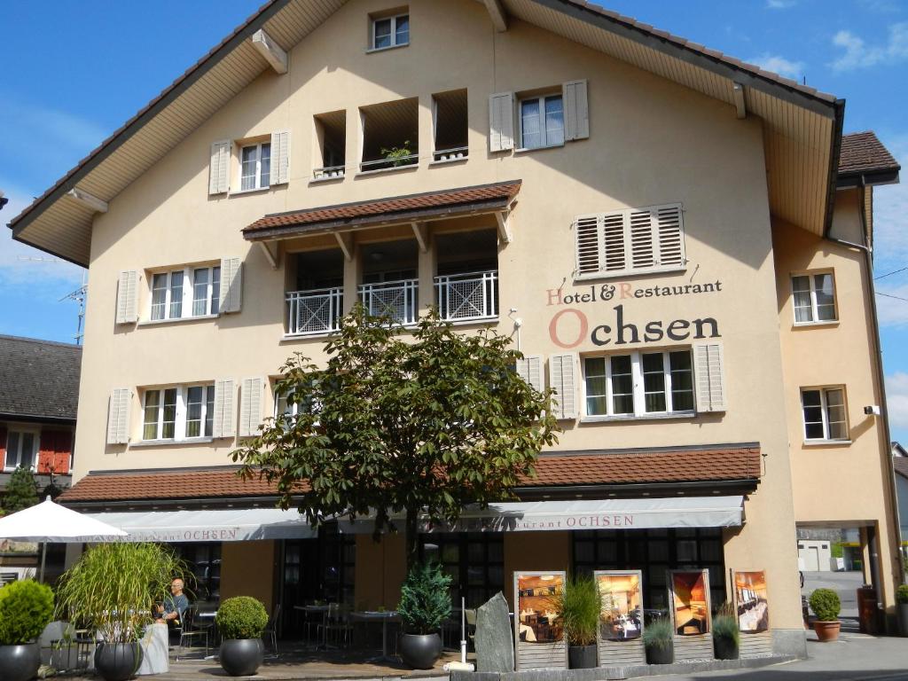 un gran edificio con un cartel que dice Oliver en Hotel Ochsen, en Menzingen