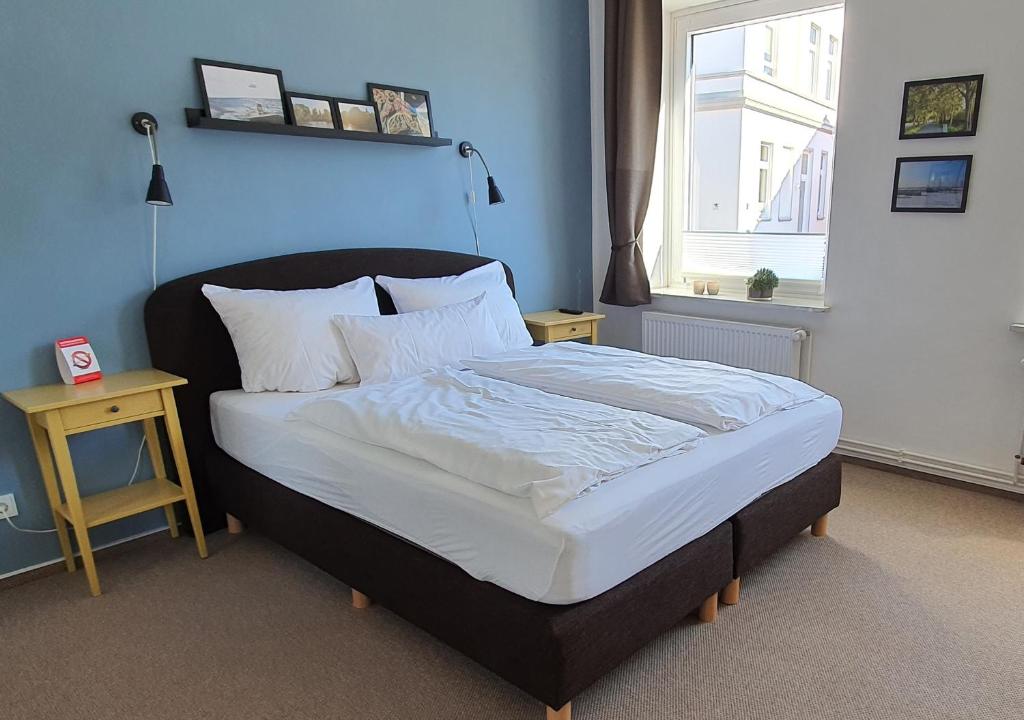 a bedroom with a bed with white sheets and a window at Gästehaus bed & kitchen in Schleswig