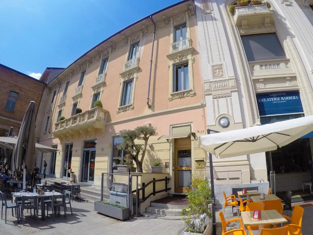 - un bâtiment avec des tables, des chaises et un parasol dans l'établissement Locanda San Paolo, à Monza