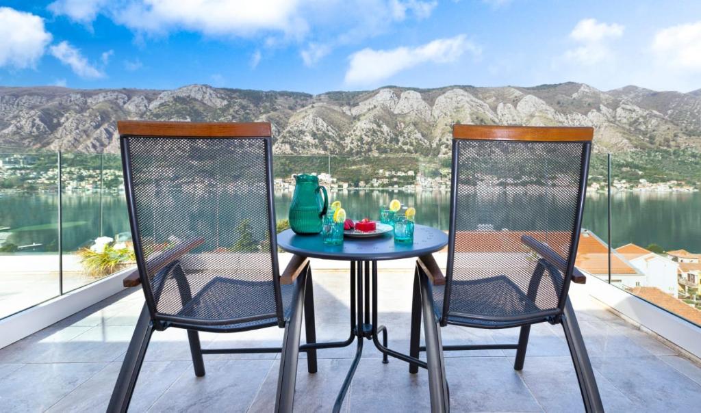 a table and two chairs on a balcony with a view at De Lux Apartments Sirena in Kotor