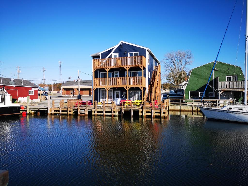 une maison sur un quai avec des bateaux dans l'eau dans l'établissement The Inn at Fisherman's cove, à Halifax