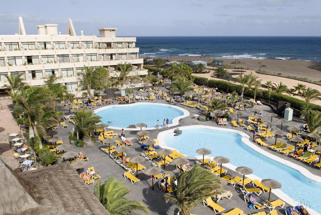 een luchtzicht op een resort met een zwembad en het strand bij Hotel Beatriz Playa & Spa in Puerto del Carmen